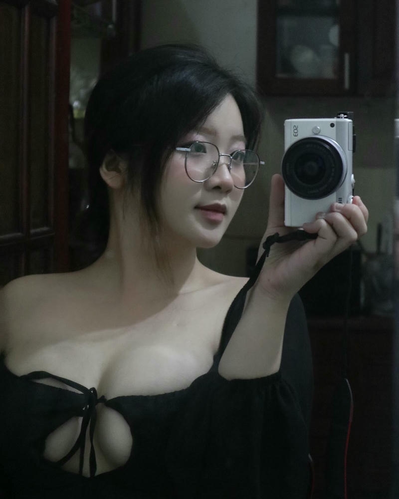 gái xinh đeo kính cầm máy ảnh